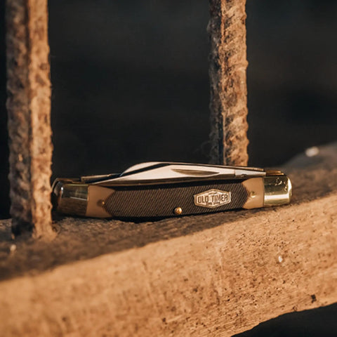 Solid As A Rock Pocket Folder With 2 Inch Clip Point Blade Crafted From High Carbon Stainless Steel and Rough Cut Sawcut Grip on rustic wood.