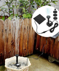Solar Powered Fountain Kit For Bird Baths And Small Ponds No Wiring Easy Setup Outdoor Water Pump For Patio Gardens And Fish Tanks Eco Friendly Solar Panel Pump For Garden Water Features installed in bird bath with wood fence in background.