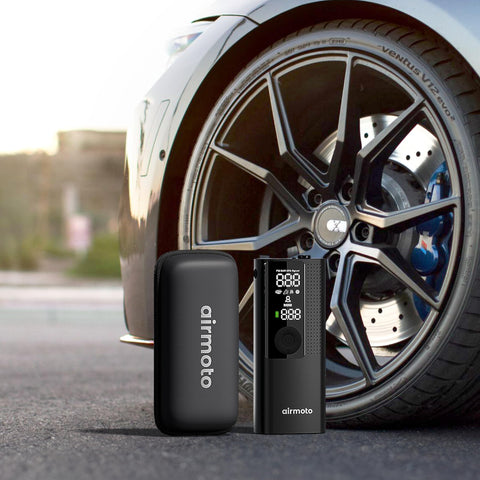Portable Cordless Tire Inflator With Hard Case Bundle Quick Accurate Air Pump For Car Truck SUV Motorcycle And Bicycle 120 PSI Gauge Compact Air Compressor With Carrying Case next to car wheel.