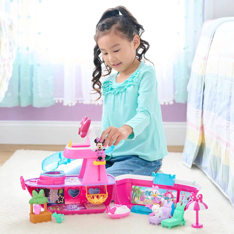 Child playing with Bowdazzling Minnie Mouse Yacht Playset with Lights and Sounds 14 Piece Boat Set on a bedroom floor.