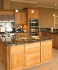 Modern kitchen interior with wood cabinets and island, marble countertops, stainless appliances, recessed lighting in warm tones.