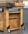 SPACEKEEPER workbench casters kit, two visible black and silver casters with orange levers on a wooden workbench.