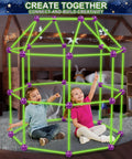 Children playing inside Glow In The Dark Fort Building Kit 140 Piece STEM DIY Castle And Tunnel Build Set For Kids Ages 4 5 6 7 8 Plus Great Christmas And Birthday Gift For Boys And Girls, assembled in a room with bright green rods and purple connectors.