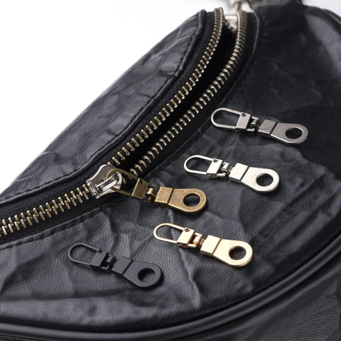 Handy Zipper Pull Replacement Kit For Small Holes With Detachable Tabs on black bag, assorted metal finishes, 4 pieces