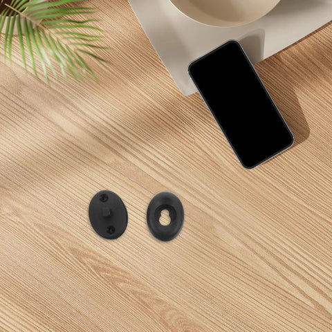 Top view of pro-grade quick-release wetsuit buckle connector set on wood table; includes black durable plastic and stainless steel replacement.