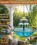 Solar Powered Hanging Bird Bath Fountain For Outdoors With Glass Bowl installed in garden with bird perched on edge.