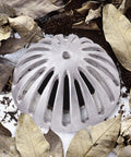 Heavy Duty Aluminum Floor Drain Dome Cover 5-1/2 Inch Width By 2-1/4 Inch Height surrounded by leaves and soil