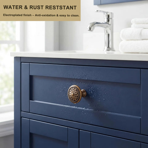 Close-up of a single antique brass cabinet knob on a blue drawer, part of 'Antique Brass Cabinet Knobs 10 Pack Tough As Nails Heavy Duty Zinc Alloy Round 1.4 Inch Dia Kitchen Cabinet Handles For Cabinets Drawers Dresser Furniture Vintage Pulls', showcasing its floral surface design.
