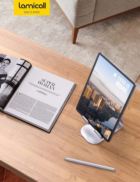 Adjustable Tablet Stand For 4 To 13 Inch Tablets And Phones Desktop Holder For iPad Pro Models Air Mini Kindle Switch Galaxy Tab And More Ideal Office Desk Accessory For Home And Work holding tablet on wooden desk with magazine and pen