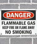 Rock Solid Heavy Duty Aluminum Danger Flammable Gas No Smoking Safety Sign 10 By 14 Inches on a brick wall.