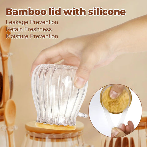 Hand holding refillable sugar jar with bamboo lid and spoon, silicone seal, 15 oz glass canister for coffee bar decor.