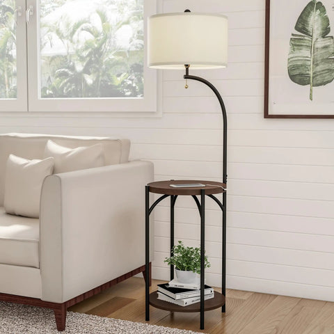 Go-To Space Saving Floor Lamp With End Table And USB Port next to a sofa in a living room, displaying black metal frame and wooden shelves.