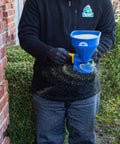 Man using Spyker Winter Weather Deicing Kit With Ergo Pro 50 Pound Spreader And 5 Pound Handheld Spreader, ice melt on walkway.