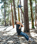 Child using Zip Line Kit 150 Feet With Seat And Carabiner Heavy Duty One Quarter Inch Galvanized Cable Backyard Fun For Families Supports Up To 350 Lbs Weather Resistant Easy Setup For Hours Of Outdoor Adventure in forest