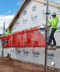 Titan Pump Jack Safety Net, red mesh, 22' long, attached to construction scaffolding on a house