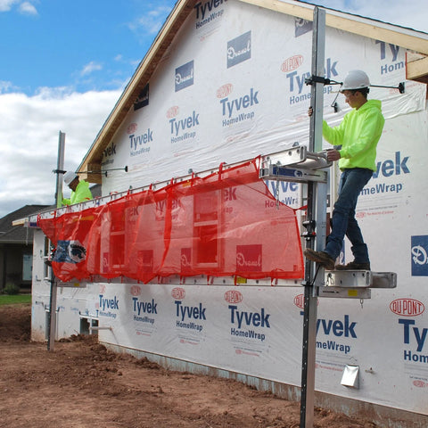 Titan Pump Jack Safety Net, red mesh, 22' long, attached to construction scaffolding on a house