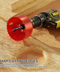 Red 4-inch bi-metal hole saw with pilot drill mounted on a cordless drill.