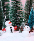 Snowman figures with carrot noses, top hats, and glove buttons from Massive Christmas Craft Button Kit With 450 Pieces Including Carrot Noses Tiny Black Buttons Mini Plastic Top Hats Glove Buttons And White Snowflake Buttons For DIY Ornaments And Holiday Decor in a snowy forest scene