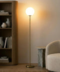Luna LED Floor Lamp Dope Modern Tall Light For Living Rooms And Home Offices With Frosted Glass Globe Mid Century Style Standing Lamp In Brass Gold Finish Perfect For Reading In The Bedroom And Cozy Vibes next to bookshelf