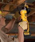 DEWALT 20V MAX cordless 4-1/2-inch grinder, yellow with battery attached, in use by worker.