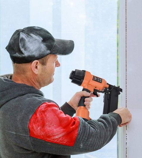 Worker using electric nailer with 16 Gauge Finish Nails 2 Inch Galvanized 2500 Count for trim on a door frame