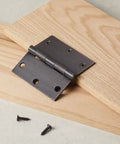 Heavy Duty 3x2 Inch Butt Hinges Black Finish 24 Pack with Plain Bearing on wooden surface
