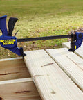 One Handed Bar Clamp Set 12 Inch Medium Duty Five Pack With Quick Change Button used on wooden planks outdoors