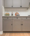 Curved Matte Black Cabinet Pulls 10 Pack For Kitchen And Home Cabinets on sleek gray kitchen cupboards, enhancing modern look.