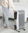 Front view of white Amazon Basics portable oil-filled radiator heater with 7 fins and 1500W on wheels.