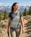Woman wearing Men's Sling Bag Crossbody Backpack on hiking trail, showcasing compact design and anti-theft features.