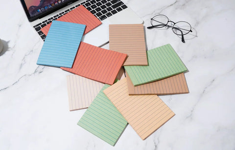 Lined Sticky Notes 4x6 Inches, 360 Sheets In 9 Packs, Vintage Colors, scattered on a desk next to a laptop and glasses.