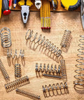 Durable Carbon Steel Compression Spring With 0.8mm Wire, 10mm Outer Diameter, And 300mm Length Perfect For Small DIY Repairs, Pen Fixes, And Home Shop Assortment Kits That Get Stuff Done Right Now, assorted springs on wooden workbench