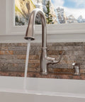 High Arc Kitchen Faucet With Pull Down Sprayer And Soap Dispenser, Single Handle, Spot Defense Stainless Finish, installed view by window