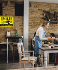 Smile You're On Camera Signs Two Pack Outdoor Video Surveillance Warning Signs 10x7 Rust Free Aluminum in a cafe setting