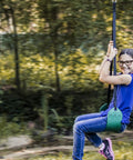 Child riding Green Zip Line Swing Seat With Nylon And Powder Coated Alloy Steel Build 250 Pound Weight Limit 40 Inch Height outdoors