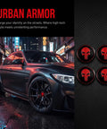 Four Pack Red Metal Skull Wheel Center Hub Cap Stickers Self Adhesive Waterproof Rim Covers Rugged Fits Trailer Grease And Bearing Dust Caps Straight Up Tough, displayed on black background next to a sleek car.