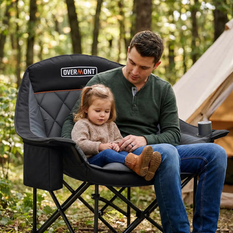 Man and child sitting on Oversized XL Camping Chair for Adults With 400 Pound Capacity Heavy Duty Padded Folding Seat Side Pocket Cup Holder Cooling Bag Included Ideal for Beach Camping RV Trips Outdoor Sports Garden and Lawn in forest