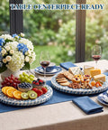 Two Pack Mother Of Pearl Lazy Susan Turntable Set With Blue Wicker 12 And 13 Inch Rotating Trays with fruits and cheeses on a table.