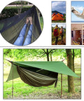 Double Parachute Nylon Camping Hammock Set With Rain Fly Tarp Mosquito Net And Tree Straps Lightweight Dope Gear For Backpacking Hiking Travel And Outdoor Yard Fun set up in a forest.