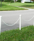 Straight Shooter White Plastic Barrier Chain One Inch Diameter Five Hundred Feet Long For Foolproof Crowd Control And Site Protection Zero Hassle Indoor Outdoor Setup Snag Free Gear That Will Easily Handle Your Daily Grind Now visible on a street with posts.