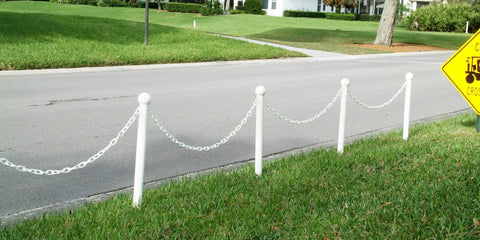 Straight Shooter White Plastic Barrier Chain One Inch Diameter Five Hundred Feet Long For Foolproof Crowd Control And Site Protection Zero Hassle Indoor Outdoor Setup Snag Free Gear That Will Easily Handle Your Daily Grind Now visible on a street with posts.