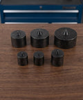 Heavy Duty Metal Shaft End Protectors For Grip-O-Matic Pullers on a wooden surface, various sizes, robust black metal material.