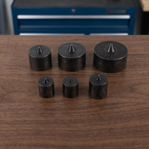 Heavy Duty Industrial Shaft End Cap Protectors 6 Piece Set arranged on a workbench, showing black metal material and varied sizes.