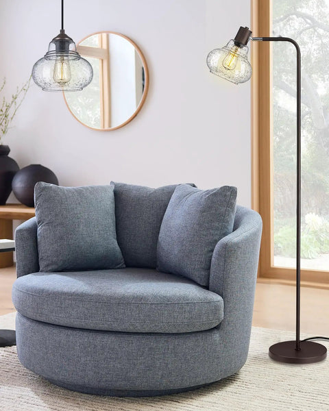 Farmhouse Bubble Glass Floor Lamp With Adjustable Tall Pole next to round gray chair in living room, oil rubbed bronze finish
