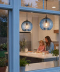 CASAMOTION Modern Farmhouse Blue Glass Globe Pendant Light 11" Dia hanging in kitchen above mother and daughter baking.