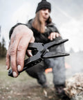 Person using 14-In-1 Multitool With Needlenose Pliers, Serrated Knife, Wire Crimper, Bottle Opener, Can Opener And Screwdriver outdoors