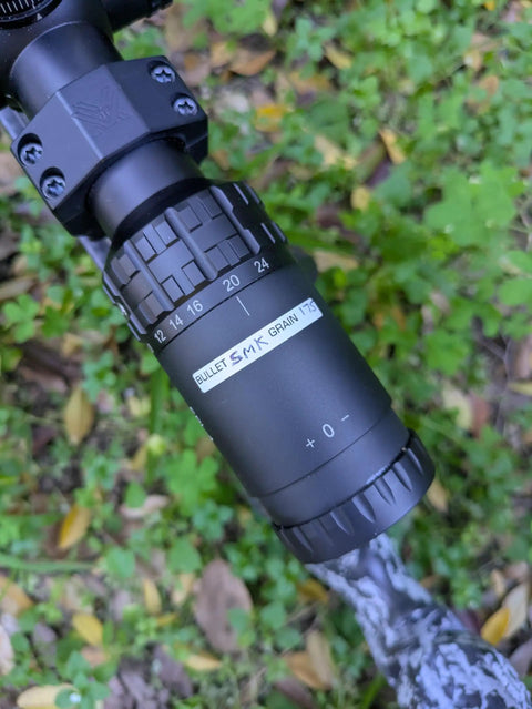 Close-up of a rifle scope with the Vinyl Rifle Scope Turret Labels Kit With 25 Yard Increments From 100 To 1000 Yards Range Day Ready