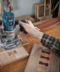 Close-up of hands using Bosch router on wood with Six Piece Universal Groove Cutter Router Bit Set With Carbide Tips for grooving