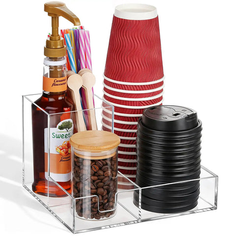 Clear Acrylic Coffee Cup Holder For Countertop With Three Compartments For Cups Lids Straws Pods Sugar Packets And Tea Bags A Handy Coffee Bar Organizer For Kitchen Counters showing cups, lids, straws, syrup, and coffee beans.