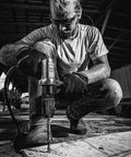 Man using a Half Inch Keyless Chuck Air Drill With Reversible Operation, 500 RPM, 0.5 HP, ergonomic grip on wooden surface.